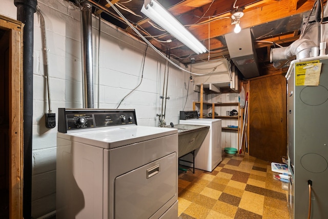 laundry area featuring concrete block wall, laundry area, washer / clothes dryer, and light floors