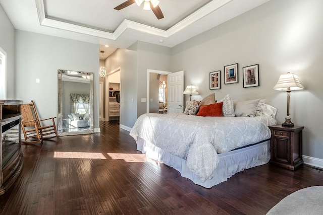 bedroom featuring baseboards, dark wood-style floors, and a tray ceiling