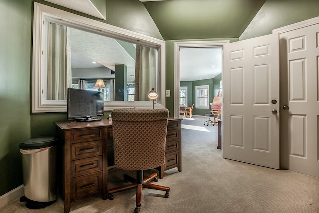 office featuring baseboards, lofted ceiling, and light colored carpet