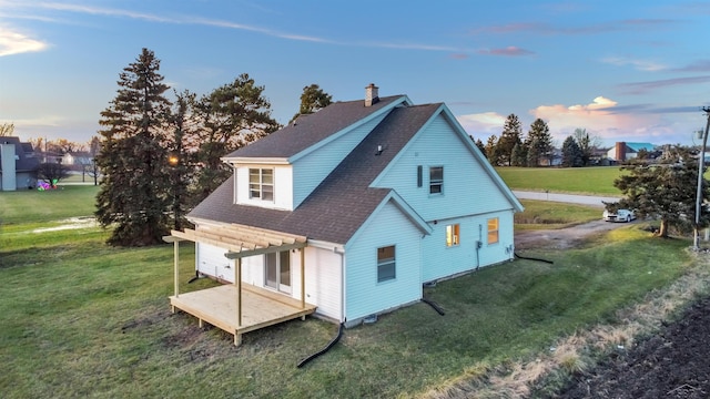 property exterior at dusk featuring roof with shingles and a lawn