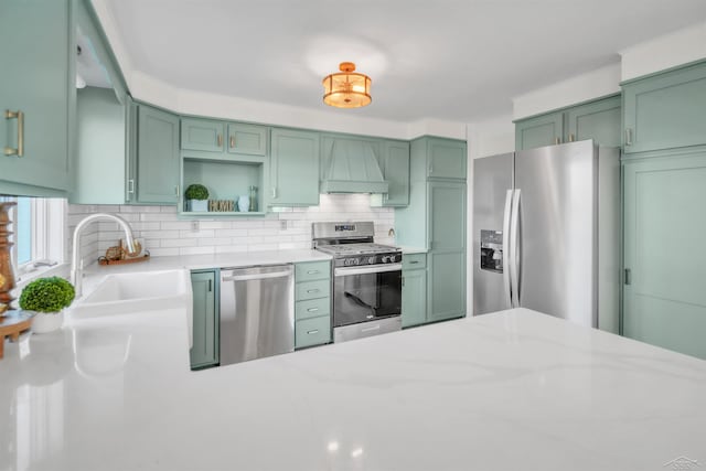 kitchen with open shelves, green cabinetry, appliances with stainless steel finishes, and custom range hood