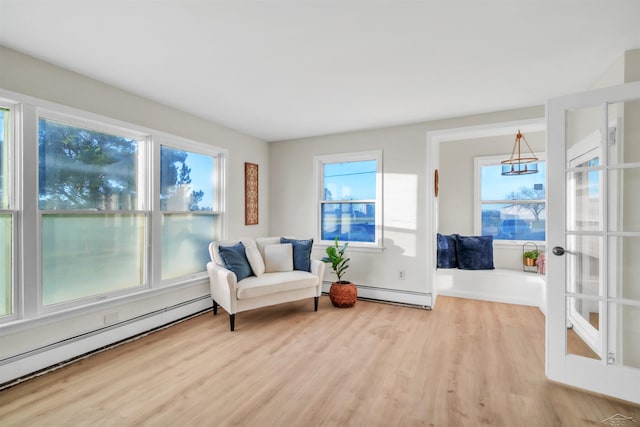 living area featuring baseboard heating and wood finished floors