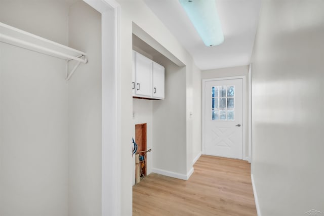 doorway featuring light wood-style flooring and baseboards