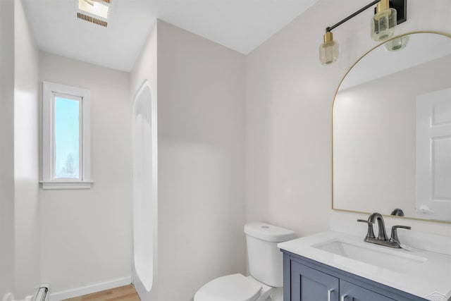 bathroom with vanity, baseboard heating, visible vents, baseboards, and toilet