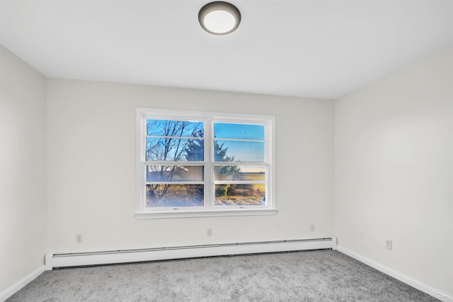 spare room featuring baseboards, a baseboard heating unit, and light carpet