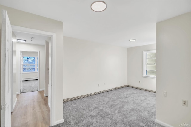 empty room featuring baseboards and light colored carpet