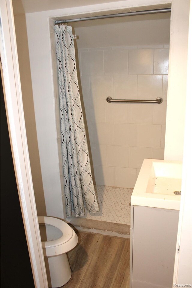 1629 Seminole St, Flint, MI 48503 - bathroom featuring a tile shower, wood finished floors, and vanity