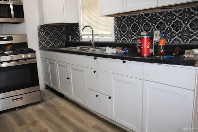 1629 Seminole St, Flint, MI 48503 - kitchen with appliances with stainless steel finishes, white cabinets, backsplash, and dark countertops