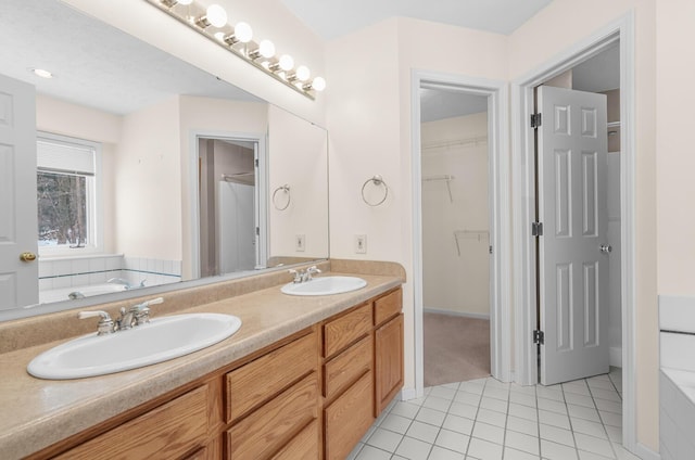 full bathroom featuring a sink, double vanity, a garden tub, and tile patterned floors