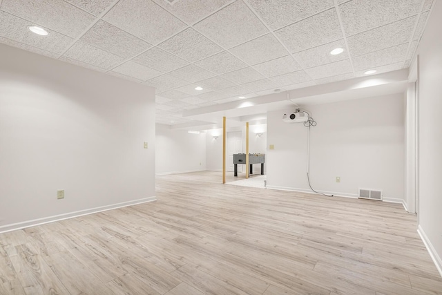 finished basement with baseboards, visible vents, recessed lighting, and light wood-style flooring