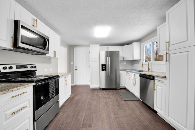 kitchen with stainless steel appliances, white cabinets, and a sink