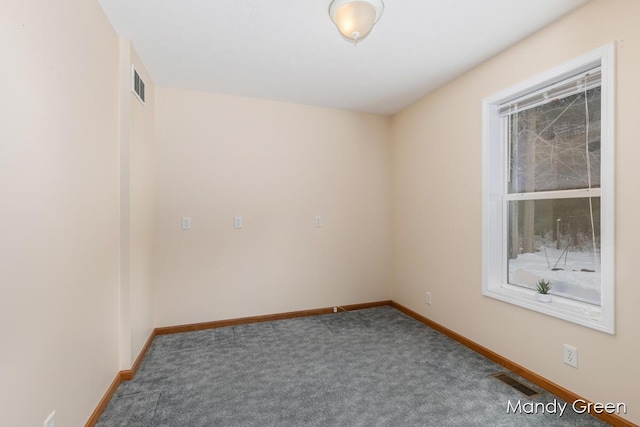 empty room featuring visible vents, baseboards, and carpet