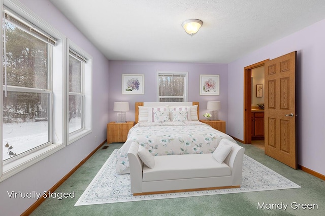 bedroom with baseboards, light carpet, ensuite bath, and visible vents