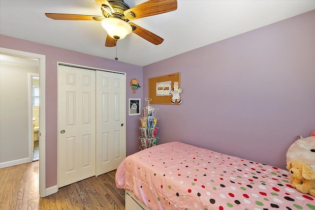 bedroom featuring a closet, ceiling fan, baseboards, and wood finished floors