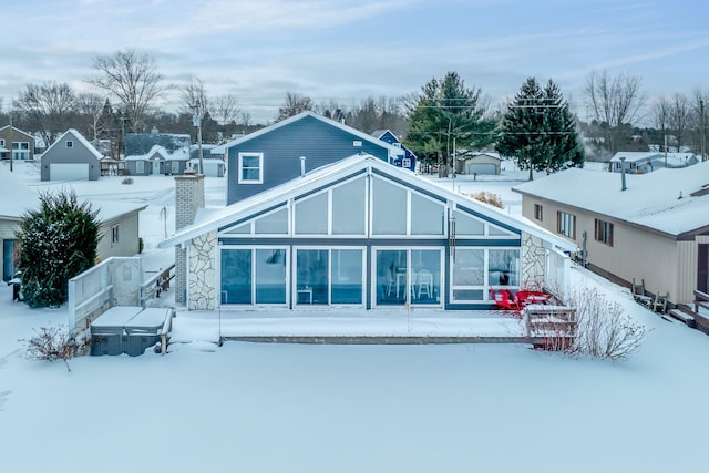 snow covered rear of property featuring fence