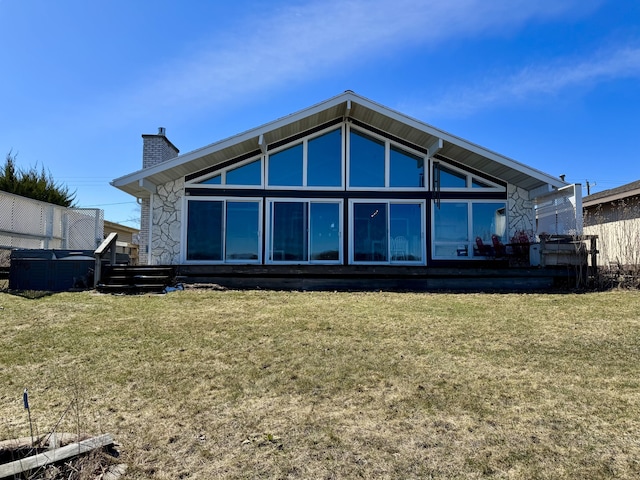 back of property featuring a lawn and a chimney