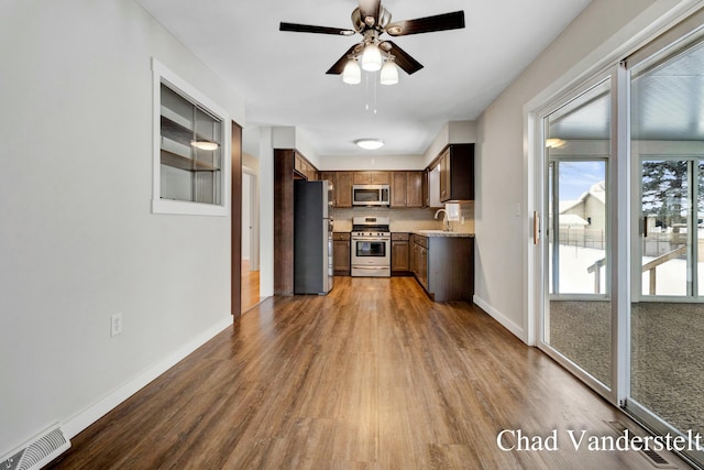 kitchen with visible vents, baseboards, a sink, dark wood finished floors, and stainless steel appliances