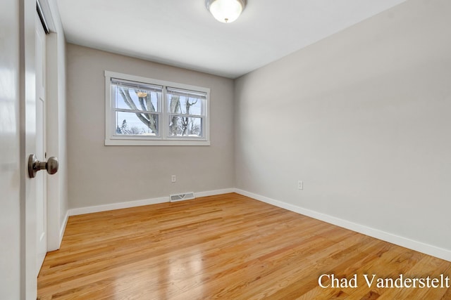 unfurnished room with light wood-style flooring, baseboards, and visible vents