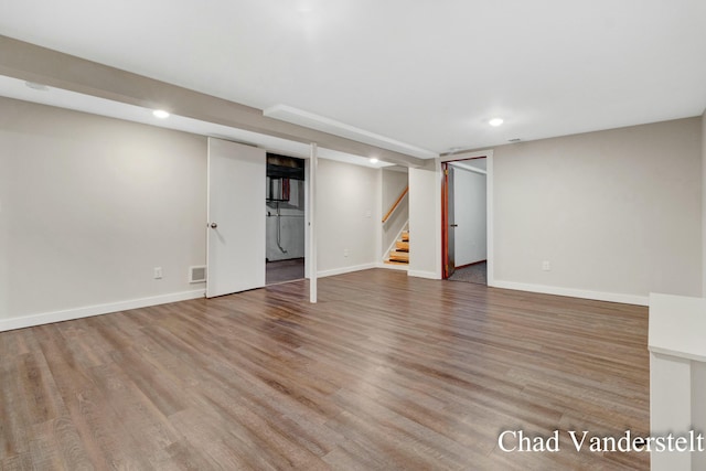 finished basement featuring stairs, baseboards, recessed lighting, and wood finished floors