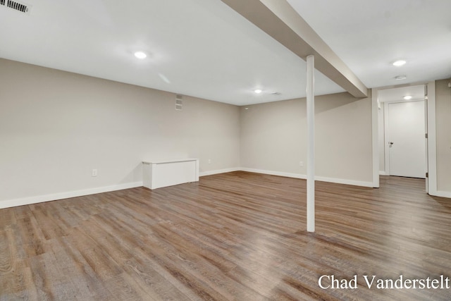 finished below grade area featuring visible vents, baseboards, recessed lighting, and wood finished floors