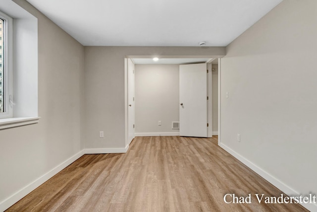 empty room featuring baseboards, visible vents, and light wood-style flooring