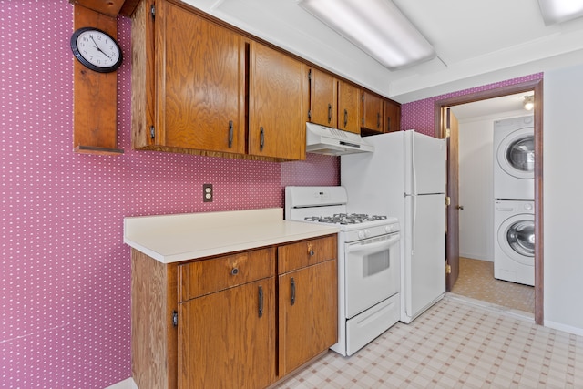 kitchen with light floors, stacked washer / drying machine, light countertops, white appliances, and under cabinet range hood