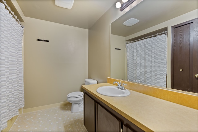 bathroom featuring vanity, tile patterned flooring, toilet, and baseboards