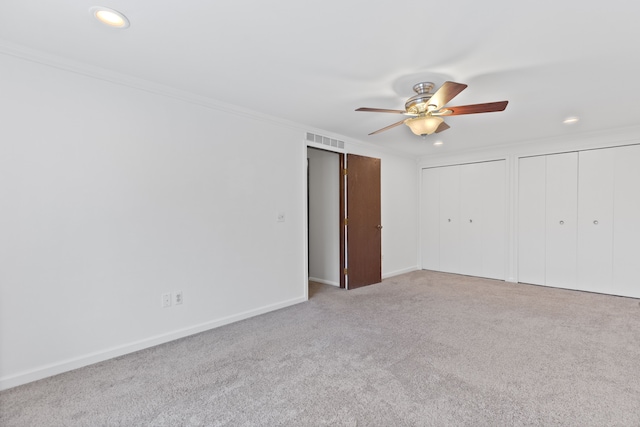 unfurnished bedroom with light carpet, visible vents, multiple closets, and recessed lighting