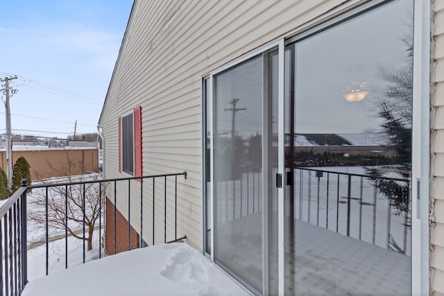 view of snow covered back of property