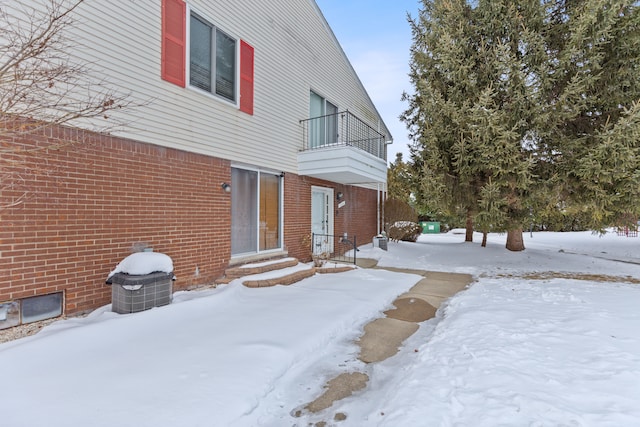 exterior space featuring entry steps, brick siding, and a balcony