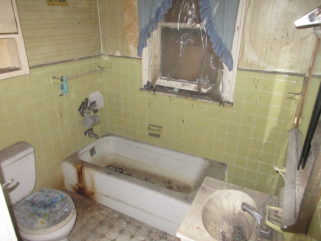 full bathroom with toilet, a bathing tub, a sink, and tile walls