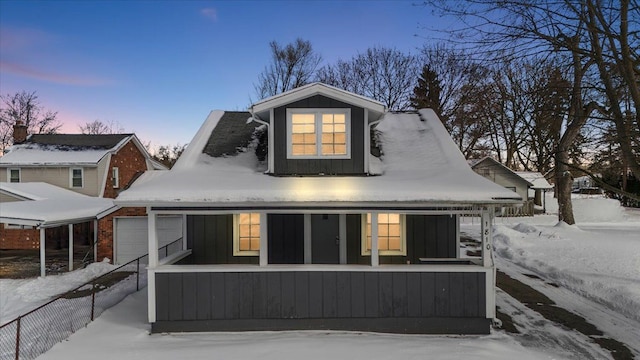 view of front of home with board and batten siding, fence, and a garage