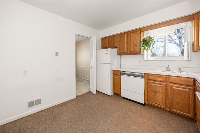 kitchen featuring light countertops, visible vents, light carpet, a sink, and white appliances