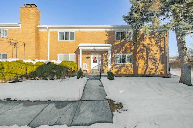 view of front of property with brick siding and a chimney