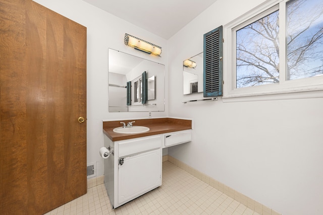 bathroom with visible vents, vanity, and baseboards