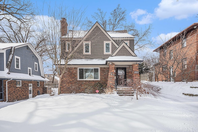 view of front of house featuring brick siding and a chimney