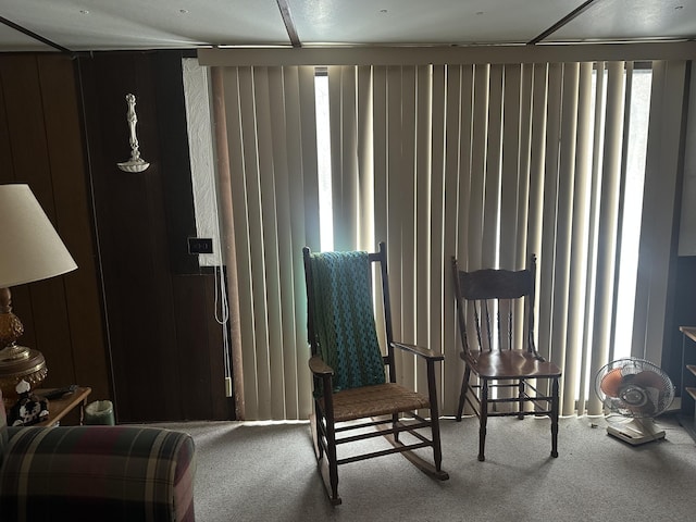 living area featuring carpet flooring and wood walls