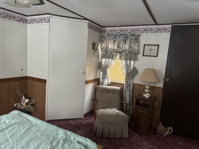 bedroom featuring dark carpet, ornamental molding, and wainscoting