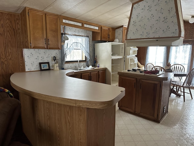 kitchen featuring a peninsula and wallpapered walls