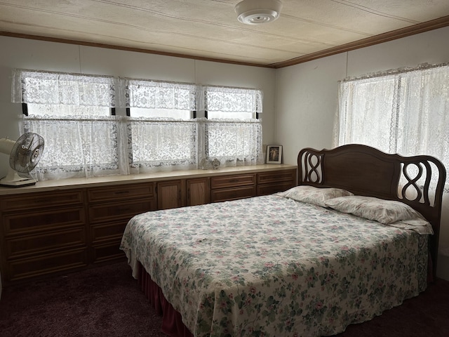 bedroom with dark carpet and crown molding