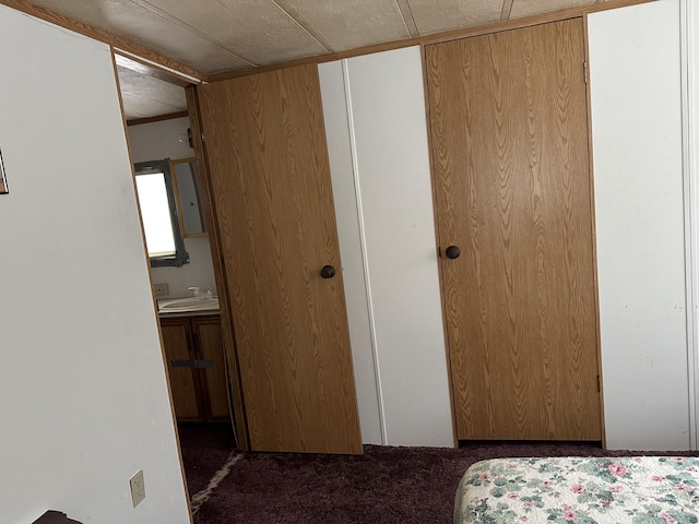 unfurnished bedroom featuring dark colored carpet and a sink