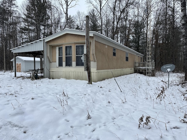 view of snow covered exterior with a carport