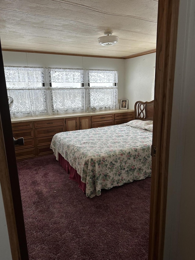 bedroom featuring dark carpet and crown molding