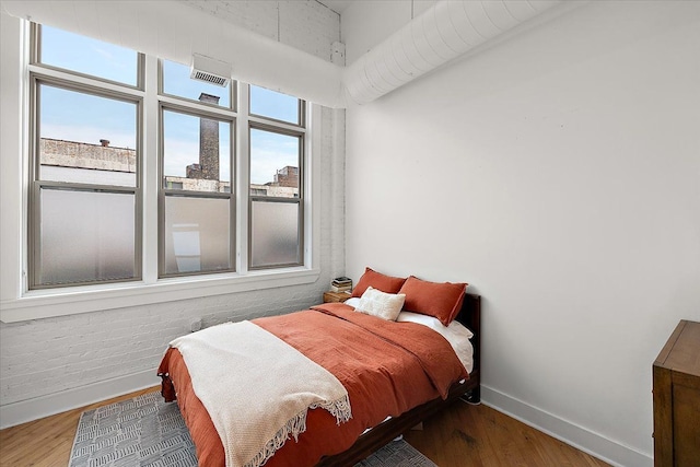 bedroom with baseboards and wood finished floors