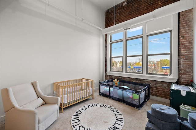 bedroom with baseboards, a towering ceiling, and brick wall