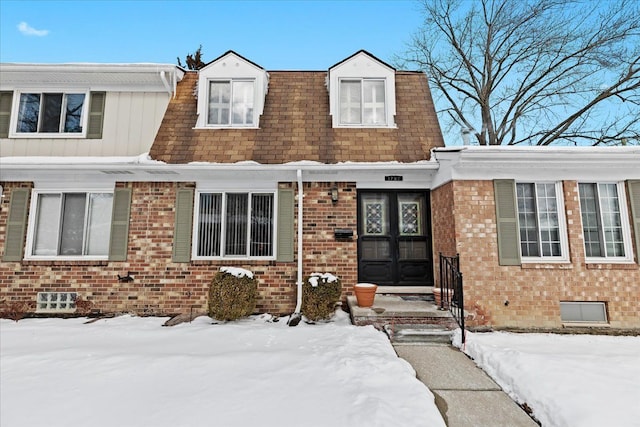 view of front of property with brick siding and roof with shingles