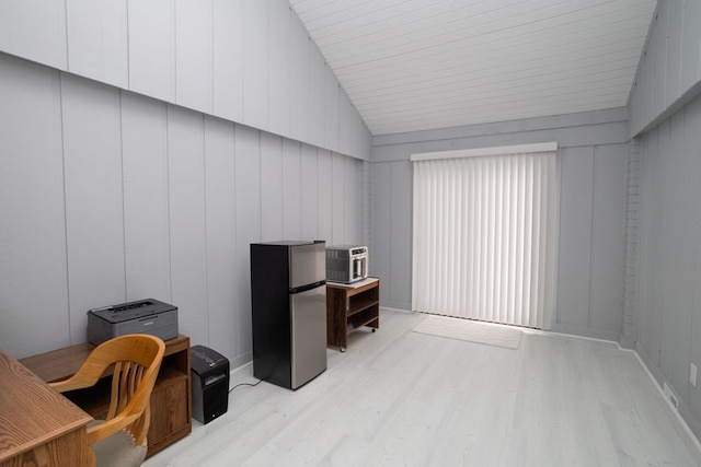 office space with vaulted ceiling and light wood-style flooring