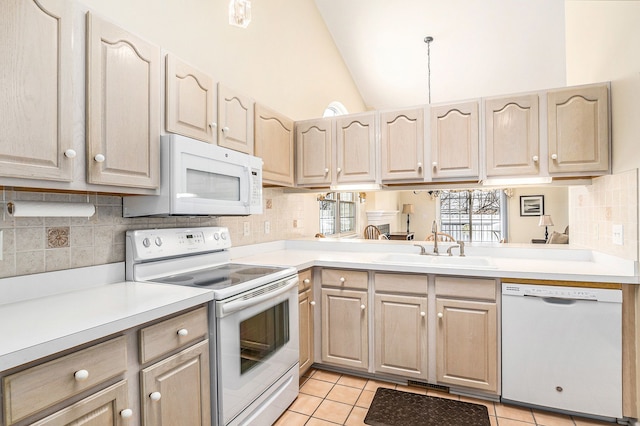 kitchen featuring white appliances, light tile patterned floors, lofted ceiling, light countertops, and a sink