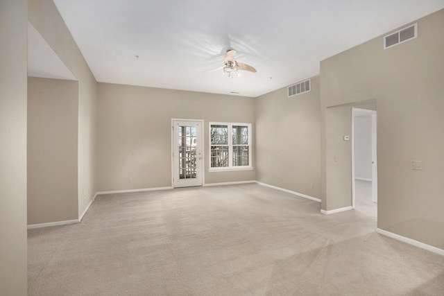 empty room with a ceiling fan, visible vents, light carpet, and baseboards