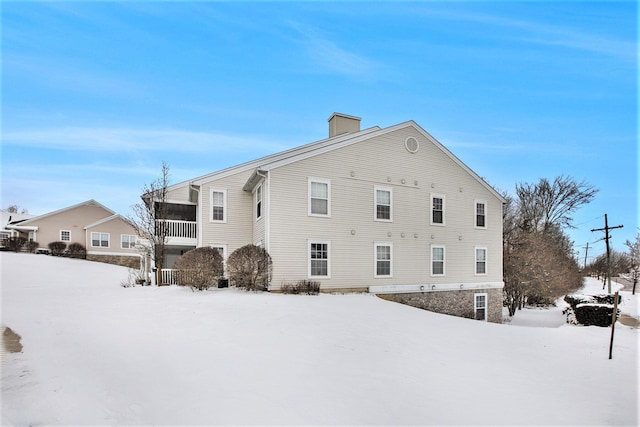 view of snow covered exterior with a chimney